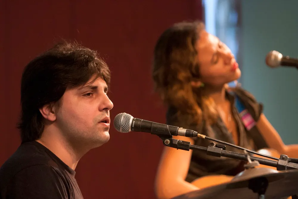 Sandro Vales cantando ao microfone em show ao vivo